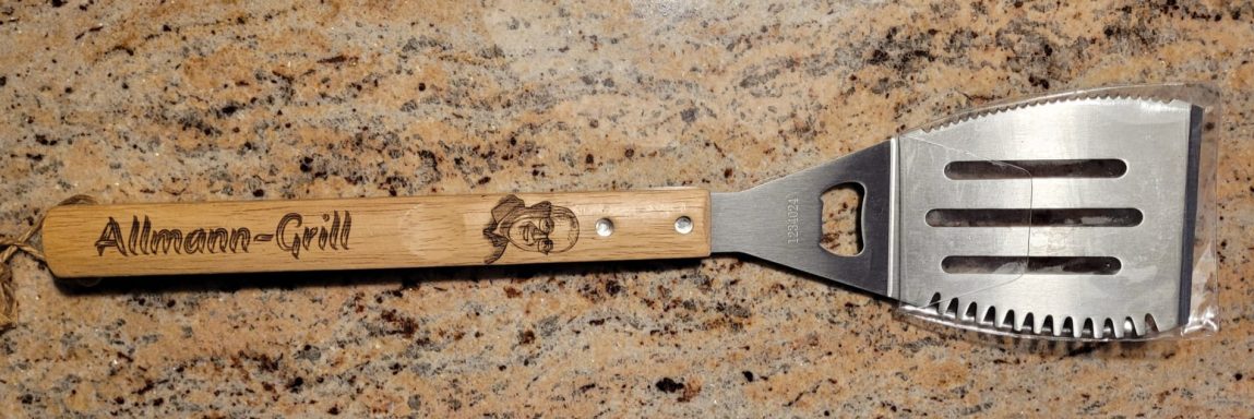 Edelstahl-Wender mit Holzgriff mit individueller Gravur und Bild Edelstahl-Wender mit Holzgriff und gestanztem Logo.