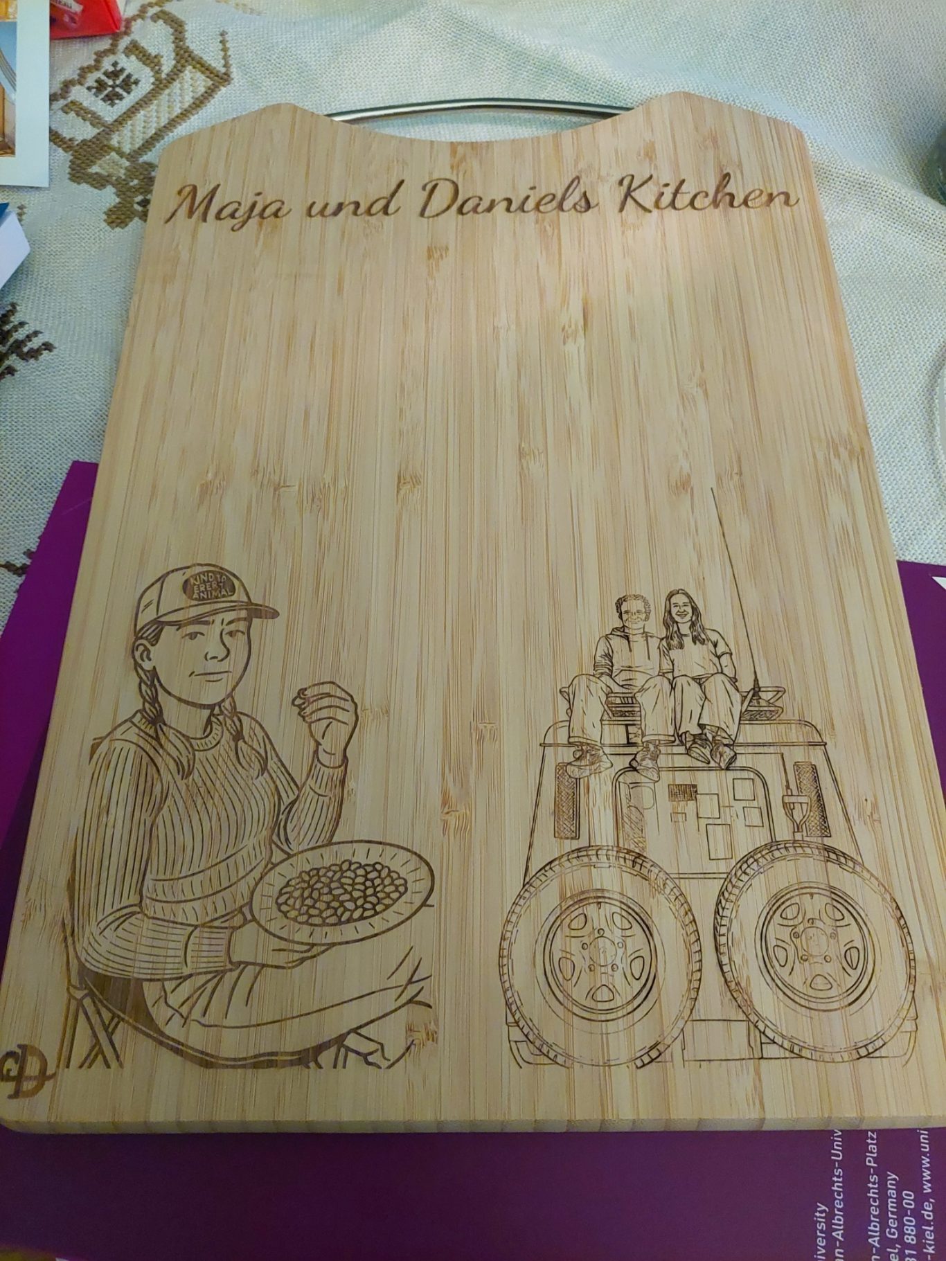 Holzbrett / Schneidebrett mit personalisierter Gravur und Motiv Holzbrett mit gravierten Motiven einer Köchin und einer Küche.